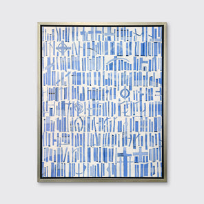 A blue and white abstract print in a silver floater frame hangs on a white wall.