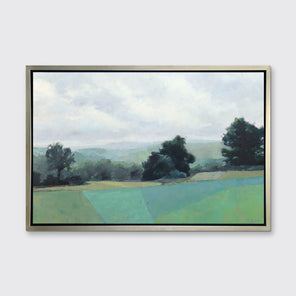 A landscape print in a silver floater frame hangs on a white wall.