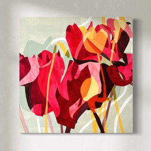 A colorful abstract floral artwork on a wall, featuring predominantly red and pink tones with touches of yellow and green hanging on a white wall.