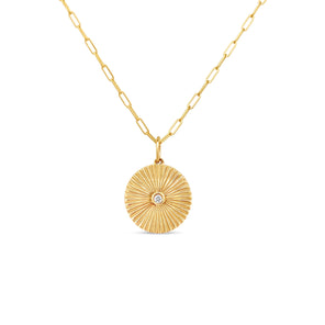 Gold necklace with a round pendant on a white background