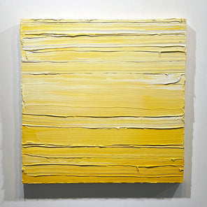A textured yellow toned painting by Teodora Guererra hangs on a white wall.