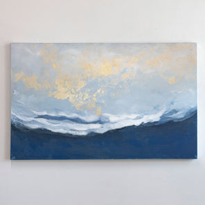 A blue, white, and gold abstract painting hangs on a light wall. 