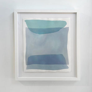 Blue and green shapes overlap in this painting by Nealy Hauschildt in a white frame floating above a white matte hangs on a white wall.