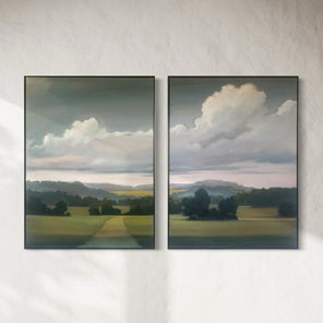 Two landscape paintings with green fields and cloudy skies on a white wall.
