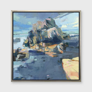 A blue, green and yellow abstract landscape print in a silver floater frame hangs on a white wall.