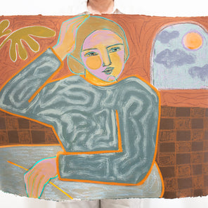 A person holds a yellow, orange, and grey abstracted figure painting in front of a white wall. 