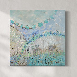 A blue and turquoise abstract painting hangs on a white wall. 
